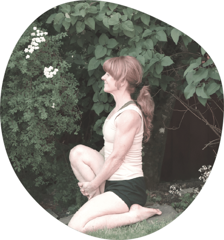 Yoga teacher practicing a seated twist outdoors in a garden setting